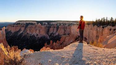 Open a new checking or savings account today! - Woman standing on edge overlooking Bryce Canyon's red rock vista.